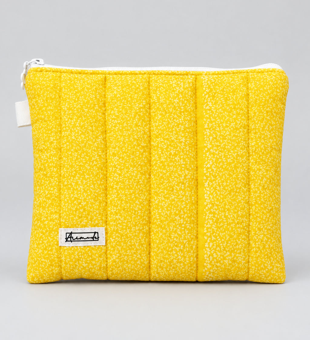 A bright yellow quilted pouch with a textured speckled pattern.